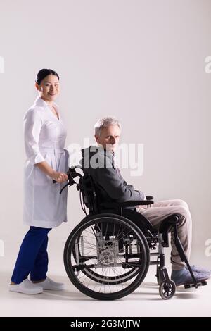 Krankenschwester Rollstuhl schieben mit dem Menschen. Stockfoto