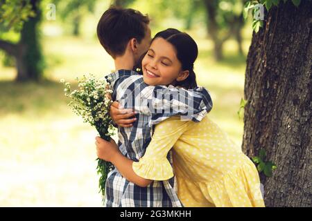 Kleine Junge geben bouqet Blumen Mädchen. Stockfoto