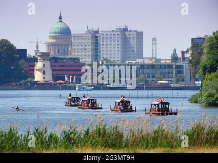 Potsdam, Deutschland. Juni 2021. Kleine Hausboote segeln vor der Kulisse der Potsdamer Innenstadt am Tiefensee oder der Havel am Schilfufer des Glienicker Parks vorbei. Quelle: Soeren Stache/dpa-Zentralbild/ZB/dpa/Alamy Live News Stockfoto