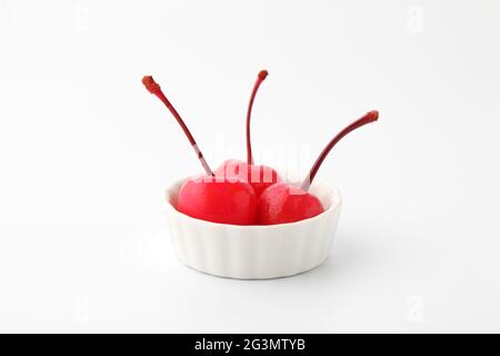 Rote Kirschen aus der Dose in Sirup auf Platte isoliert auf weißem Hintergrund Stockfoto
