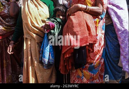 '13.04.2014, Haridwar, Uttarakhand, Indien - EIN kleines Kind steht während der Hindu-Religiou inmitten weiblicher Pilger in ihren bunten traditionellen Gewändern Stockfoto