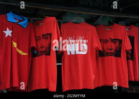 '10.11.2015, Yangon, , Myanmar - Rote T-Shirts mit dem Bild von Aung San Suu Kyi und der Aufschrift 'We won NLD' stehen in der Form an einem Straßenstand zum Verkauf Stockfoto