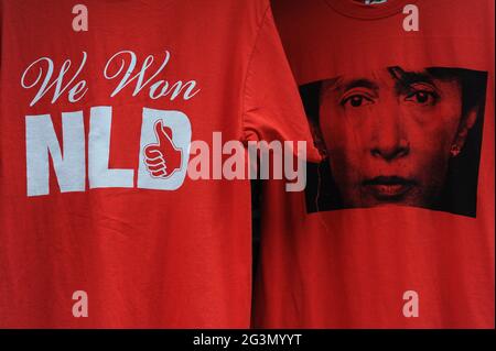 '10.11.2015, Yangon, , Myanmar - Rote T-Shirts mit dem Bild von Aung San Suu Kyi und der Aufschrift 'We won NLD' stehen in der Form an einem Straßenstand zum Verkauf Stockfoto