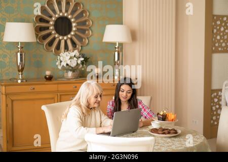 Ältere Frauen und junge Frauen, die am Laptop arbeiten Stockfoto