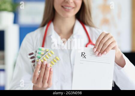Doktor hält in seinem Handkrug mit Pillen und Rezepturform Stockfoto