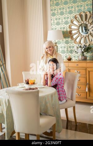 Liebevolle Umarmungen zwischen älterer Mutter und junger Tochter. Stockfoto