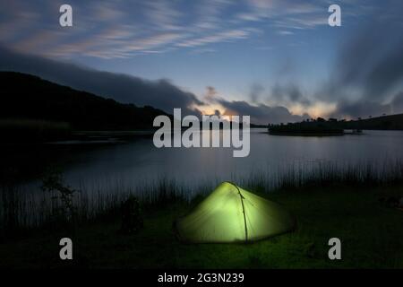 Outdoor-Abenteuer im Zelt in der Natur Siziliens, wildes Camp an einem See in der Abenddämmerung in den Nebrodi-Bergen Stockfoto