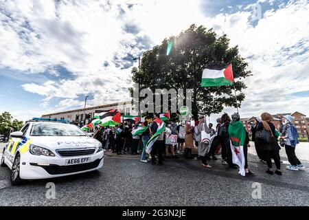 Manchester, Großbritannien. Juni 2021. Polizeiauto fährt während des Protestes an Protestierenden vorbei, die palästinensische Flaggen aufriefen und aufriefen.Demonstranten versammeln sich zu einem protestmarsch von Hulme zur Universität Manchester, nachdem sich Studenten aus Israel ausgetauscht hatten und die Schaffung von Waffen mit Graphene gefördert wurde. Kredit: SOPA Images Limited/Alamy Live Nachrichten Stockfoto