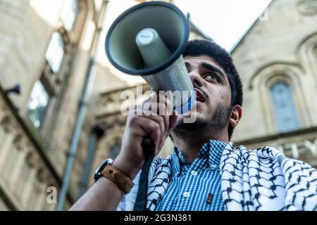 Manchester, Großbritannien. Juni 2021. Während des protestmarsches spricht ein Protestler mit anderen Demonstranten auf einem Megaphon.Demonstranten versammeln sich zu einem protestmarsch von Hulme zur Universität Manchester, nachdem sich Studenten aus Israel ausgetauscht hatten und die Schaffung von Waffen mit Graphene gefördert wurde. (Foto von Ryan Jenkinson/SOPA Images/Sipa USA) Quelle: SIPA USA/Alamy Live News Stockfoto