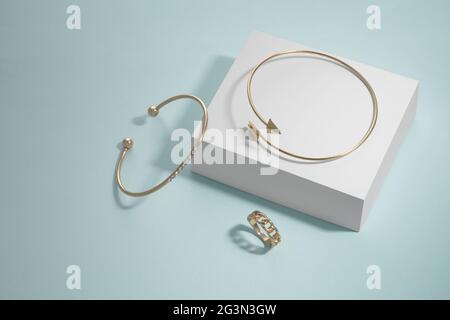 Modernes Design Pfeilform und Diamant Armbänder und Ring auf weißem Feld auf blauem Hintergrund Stockfoto