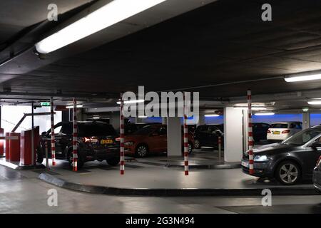 Tiefgarage. Ein Auto wartet am Ausgang vor der Schranke, die nach oben fährt, und das Auto darf wegfahren. Ein anderes Auto kommt an Stockfoto