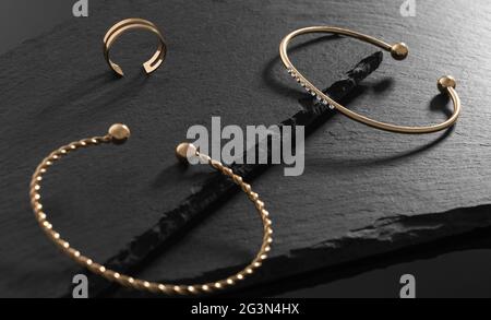 Modernes Armband mit Diamanten und modernem Ring auf schwarzen Steinplatten Stockfoto