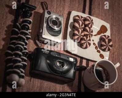 Ein paar alte Kameras zeigten sich wunderschön mit einer Tasse Kaffee und ein paar Süßigkeiten, Pentax K1000, Camera Vintage. Stockfoto