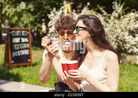 Glücklich attraktives junges Paar romantisch essen eine frische Pizza im Freien. Stockfoto