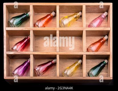 Bunte kleine Flaschen in einer Holzkiste Stockfoto