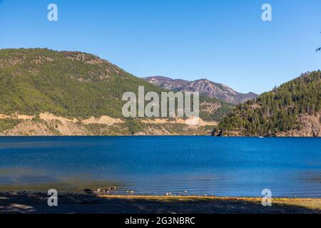 Schöner Blick auf den Lacar See, umgeben von grünen Bergen unter dem blauen Himmel Stockfoto