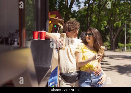 Glücklich attraktives junges Paar romantisch essen eine frische Pizza im Freien. Stockfoto