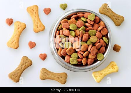 Hundefutter in der Schüssel und knochenförmige Kekse Stockfoto