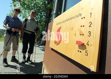 Schierke, Deutschland. Juni 2021. Besucher des Nationalparks Harz informieren sich über den aktuellen Waldbrandstand. Heißes trockenes Wetter verursacht in Sachsen-Anhalt ein erhöhtes Waldbrandrisiko. Im Harz wird derzeit Waldbrand der Stufe 4 erreicht. Quelle: Matthias Bein/dpa-Zentralbild/dpa/Alamy Live News Stockfoto