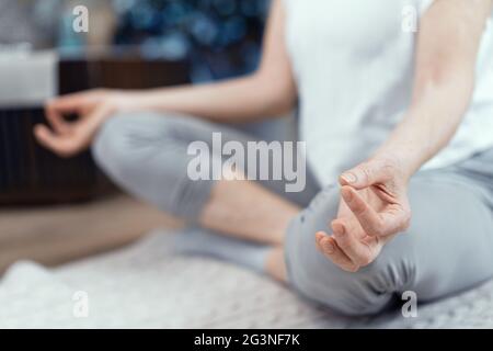 Eine Frau im Alter von über 50 Jahren ist Yoga zu Hause. Stockfoto