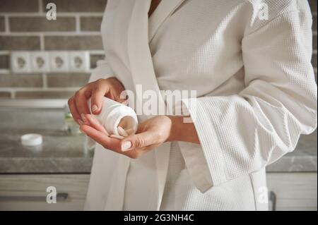 Nahaufnahme der Frau Gießen Pillen aus einem Behälter in die Hand .Medical Thema, unter Vitaminen, medizinische Therapie. Konzepte für einen gesunden Lebensstil, Haut und b Stockfoto