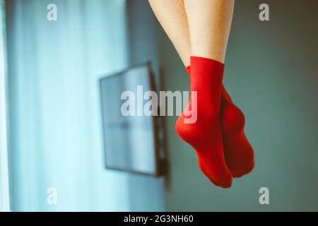 Damenbeine in roten Socken, die vom Bett hängen, Doppelstockbetten Stockfoto