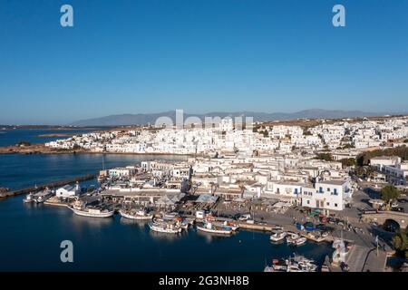 Insel Paros, Naousa Griechenland, Kykladen. Luftdrohnenansicht der Stadtansicht. Weiß getünchte Gebäude an der Küste von Naoussa, kykladische Architektur. Traditionelle Boote Stockfoto