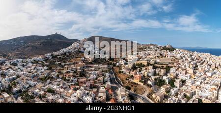 Syros Insel, Griechenland, Kykladen Hauptstadt Ermoupolis Stadtbild Panorama, Ano Siros oder Syra Stadt Panorama Drohne Ansicht, wolkig blauer Himmel Hintergrund. Stockfoto