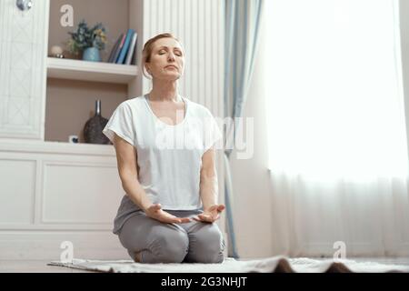 Attraktive reife Frau praktiziert Yoga in Frieden Stockfoto