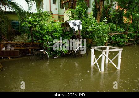 Die Straßen von Kalkutta sind in den heutigen heftigen Regen eingetaucht. Eine Rikscha sinkt im Regenwasser. Stockfoto