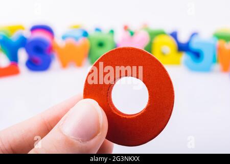 Hand hält Buchstabenwürfel O des Alphabets Stockfoto