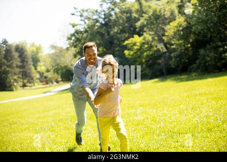 Vater jagt seine niedliche kleine Tochter, während er im Park spielt Stockfoto