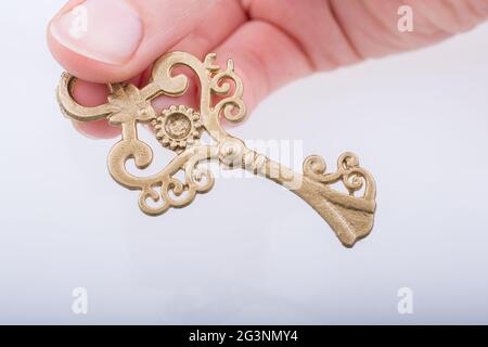 Kinderhand mit einem goldenen Farbschlüssel im Retro-Stil Stockfoto