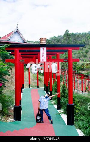 Asiatische Reisende thailändische Frauen reisen zu Besuch im Posing Portrait mit dem Red torii Tor des Wat Khao Sung Chaem Fa Tempels auf dem Khao Sam SIP Hap Berg bei Tha Maka Stockfoto