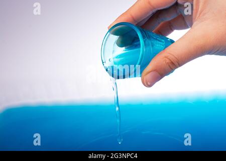 Wasser, das in der Hand aus dem Glas fließt Stockfoto