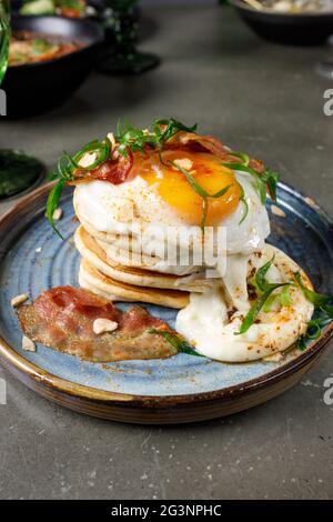 Pfannkuchen mit Speck, Spiegeleiern und geschmolzenem Käse Stockfoto