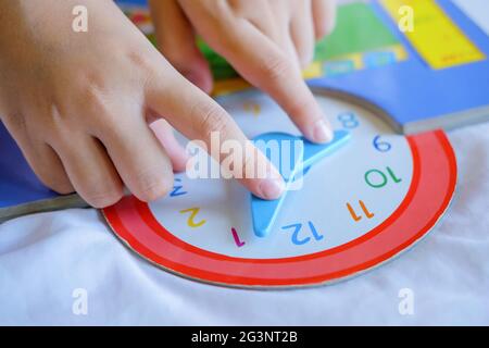 Kind spielen sagen Zeit Spiel, kleine Kinder zu lernen, wie man eine analoge Uhr zu lesen. Stockfoto