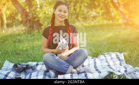 Hübsche Asiatin Hugging Bunny auf Sommer Natur Stockfoto