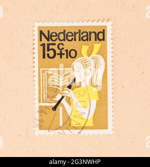 Die Niederlande 1960: einen Stempel in den Niederlanden gedruckten zeigt ein Kind, das auf der Flöte, um 1960 Stockfoto