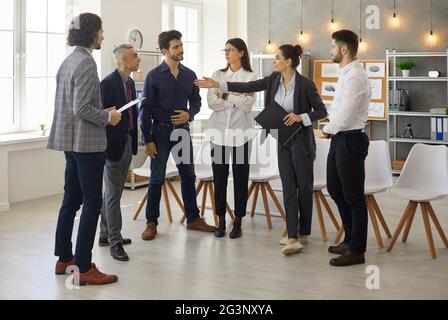 Leiter und Mitglieder des Geschäftsteams sprechen im Halbkreis im Büro Stockfoto