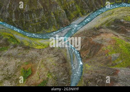 Die Luftaufnahme eines milchig blauen Flusses und eines Wanderweges in Island von oben nach unten. Stockfoto