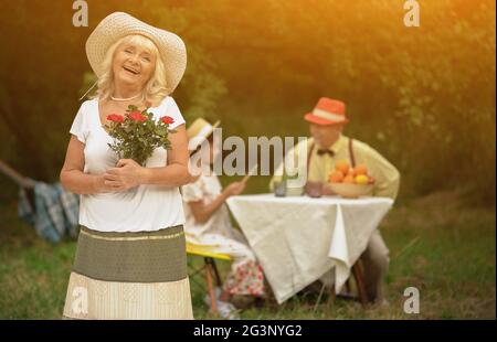 Schönen Granny mit einem Strauß roter Rosen in den Händen Stockfoto