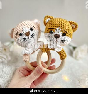 Handgemachtes Häkeltier-Spielzeug - Amigurumi Stofftier - Baby-Beißring aus Holz mit einer Katze Stockfoto