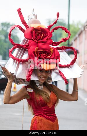 Ascot, Großbritannien. Juni 2021. Racegoer Tracy Rose kommt am Ladies Day in Royal Ascot an und trägt einen Hut mit zwei großen roten Rosen. Trotz Covid-Einschränkungen und wechselhaftem Wetter einschließlich etwas Regen zeigten viele Rennfahrer die aufwendigen Hüte und Faszination, für die der Gold Cup Day bekannt geworden ist. Kredit: Mark Kerrison/Alamy Live Nachrichten Stockfoto