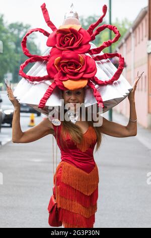 Ascot, Großbritannien. Juni 2021. Racegoer Tracy Rose kommt am Ladies Day in Royal Ascot an und trägt einen Hut mit zwei großen roten Rosen. Trotz Covid-Einschränkungen und wechselhaftem Wetter einschließlich etwas Regen zeigten viele Rennfahrer die aufwendigen Hüte und Faszination, für die der Gold Cup Day bekannt geworden ist. Kredit: Mark Kerrison/Alamy Live Nachrichten Stockfoto