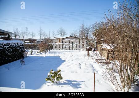 Im Winter ruht ein kleiner schneebedeckter Schottergarten Stockfoto