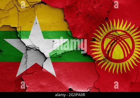 Flaggen von Myanmar und Kirgisistan auf rissige Wand gemalt Stockfoto