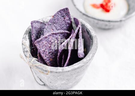 Authentische violette Mais-Chips mit Chili Dip – FOODPIX – PLATZ FÜR TEXT, COPYSPACE Stockfoto