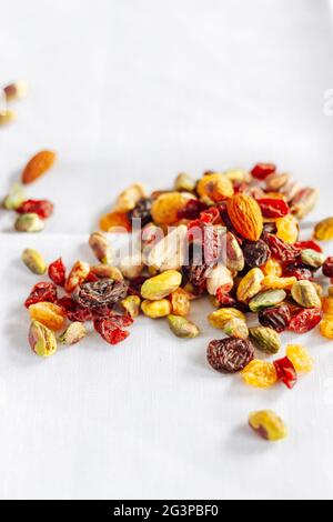 Getrocknete Früchte und Nüsse Trail Mix, Nahaufnahme, auf silbernem Tablett auf weiß Stockfoto