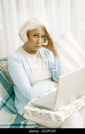 Grauhaarige ältere Frau mit Laptop Stockfoto